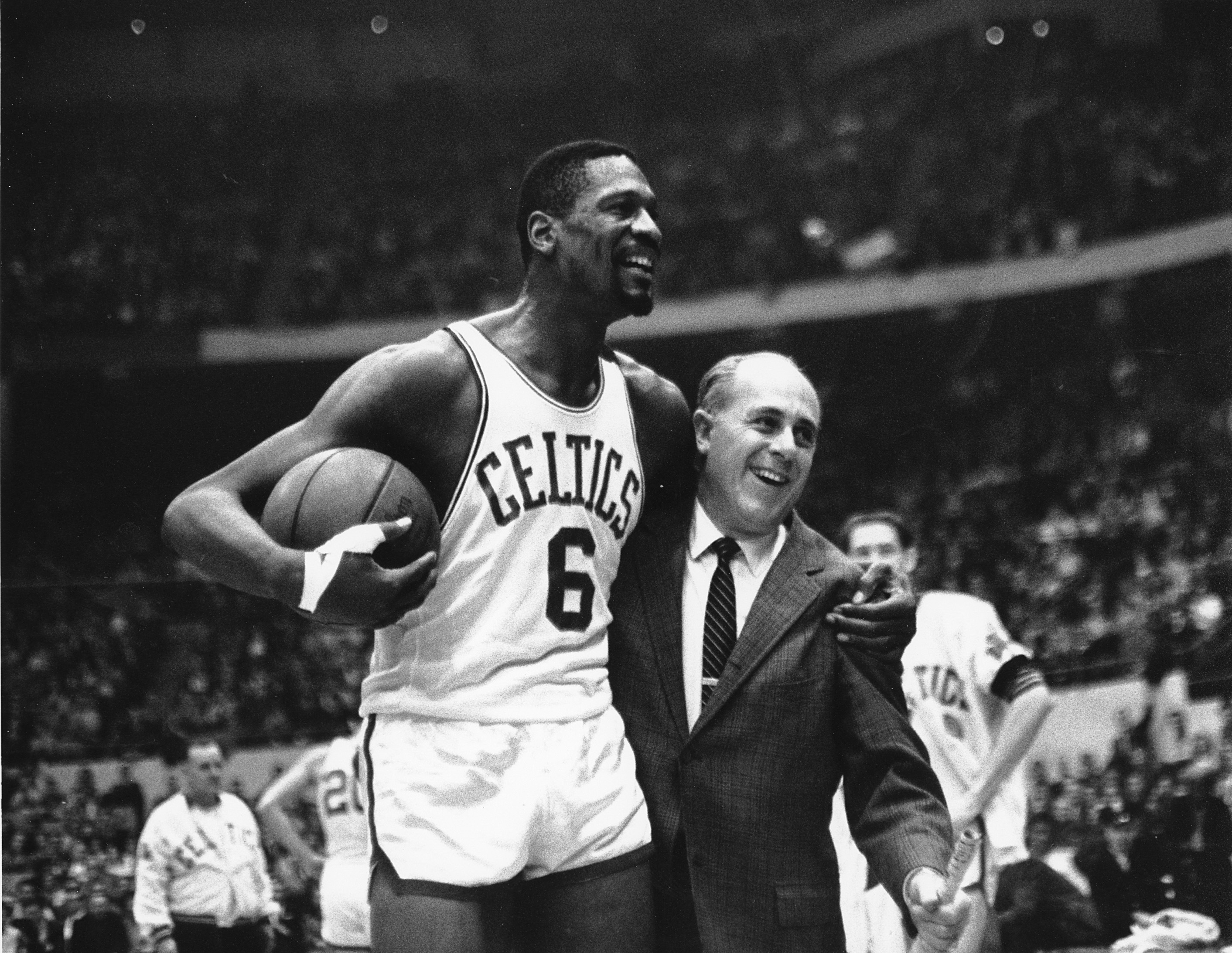 Bill Russell, left, star of the Boston Celtics is congratulated by coach Arnold "Red" Auerbach after scoring his 10,000th point in the NBA game against the Baltimore Bullets in Boston Garden on Dec. 12, 1964.