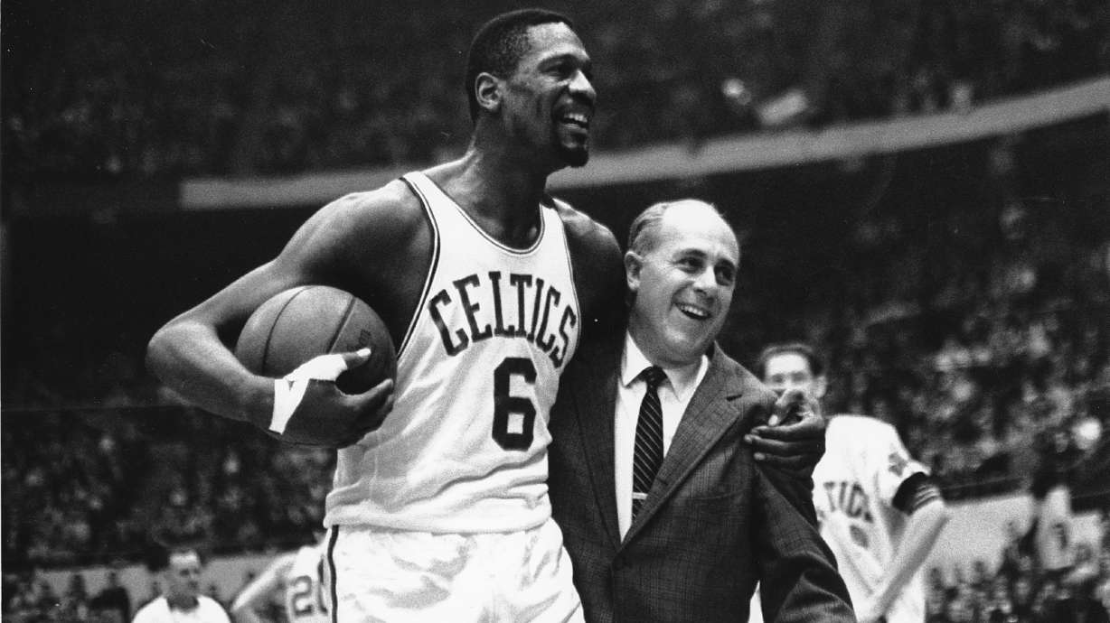 Bill Russell, left, star of the Boston Celtics is congratulated by coach Arnold "Red" Auerbach after scoring his 10,000th point in the NBA game against the Baltimore Bullets in Boston Garden on Dec. 12, 1964.