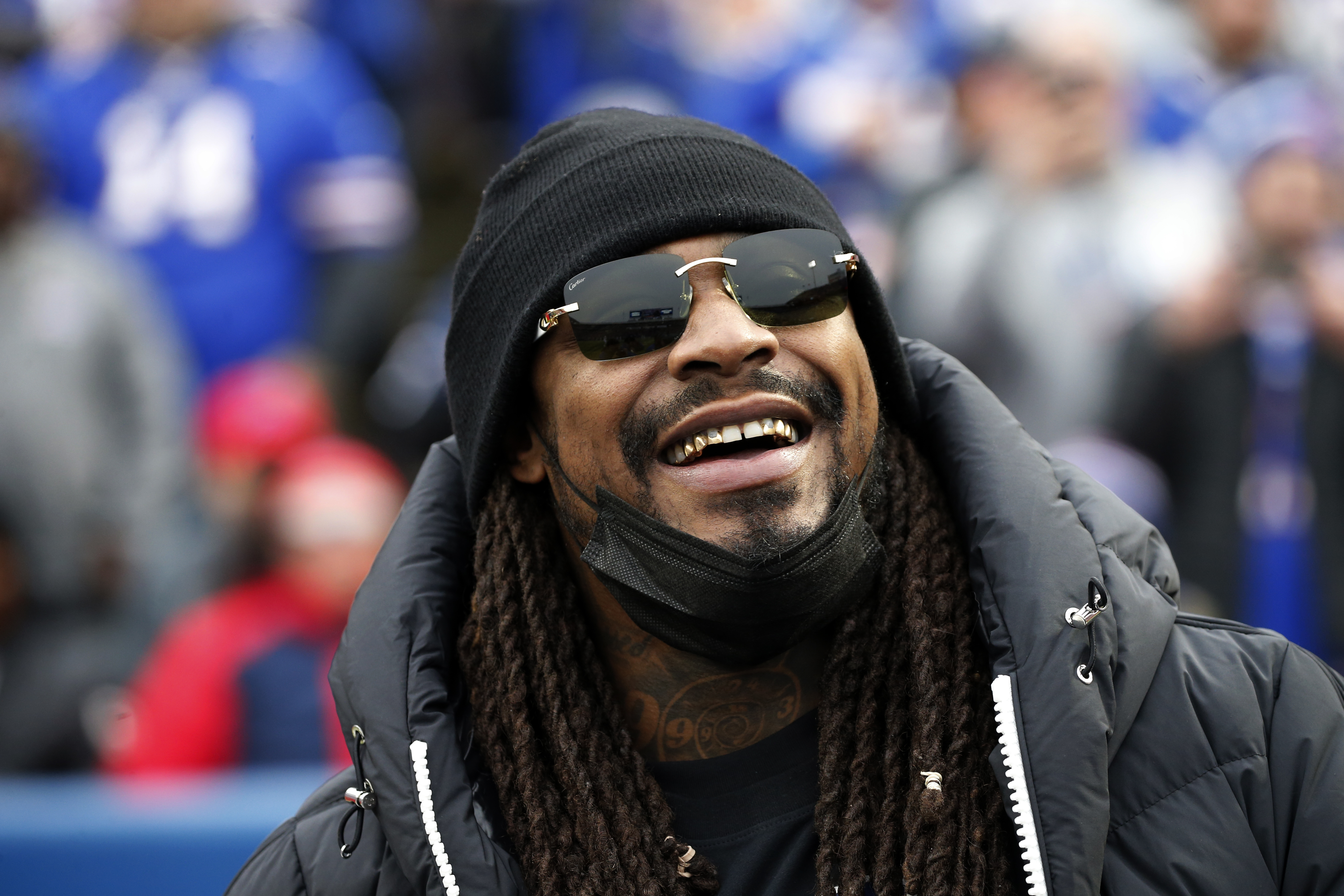 FILE - Marshawn Lynch stands on the field before an NFL football game between the Buffalo Bills and the Indianapolis Colts in Orchard Park, N.Y., Nov. 21, 2021. Police in Las Vegas say the former NFL running back was asleep and smelled of alcohol when he was found in his damaged sports car this week and arrested on suspicion of driving while intoxicated. Lynch's attorneys responded Thursday, Aug. 11, 2022, with a statement saying Lynch was in a parked car, not driving, and a DUI charge won't stick. 