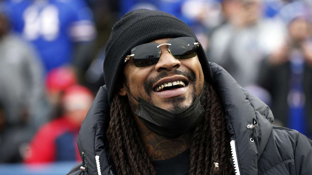 FILE - Marshawn Lynch stands on the field before an NFL football game between the Buffalo Bills and the Indianapolis Colts in Orchard Park, N.Y., Nov. 21, 2021. Police in Las Vegas say the former NFL running back was asleep and smelled of alcohol when he was found in his damaged sports car this week and arrested on suspicion of driving while intoxicated. Lynch's attorneys responded Thursday, Aug. 11, 2022, with a statement saying Lynch was in a parked car, not driving, and a DUI charge won't stick.