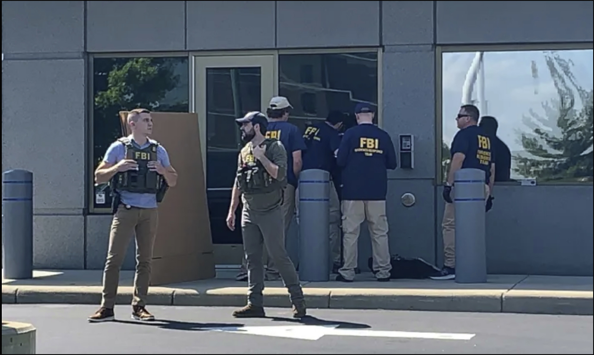 FBI officials gather outside the FBI building in Cincinnati, Ohio, Thursday. Law enforcement said Friday an armed man who tried to breach a security screening area at the FBI field office and exchanged gunfire in a standoff with law enforcement appeared to have posted calls on social media for FBI agents to be killed in the wake of the search at Donald Trump's home.