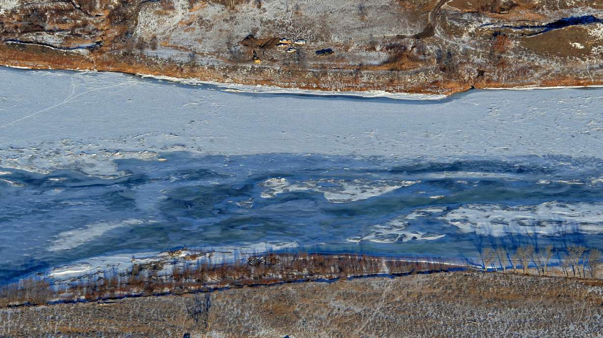 This Jan. 19, 2015 photo crews work to contain an oil spill from Bridger Pipeline's broken pipeline near Glendive, Mont., in this aerial view showing both sides of the river. Federal prosecutors are suing the Wyoming-based pipeline company for violations of pollution laws following spills in Montana and North Dakota.
