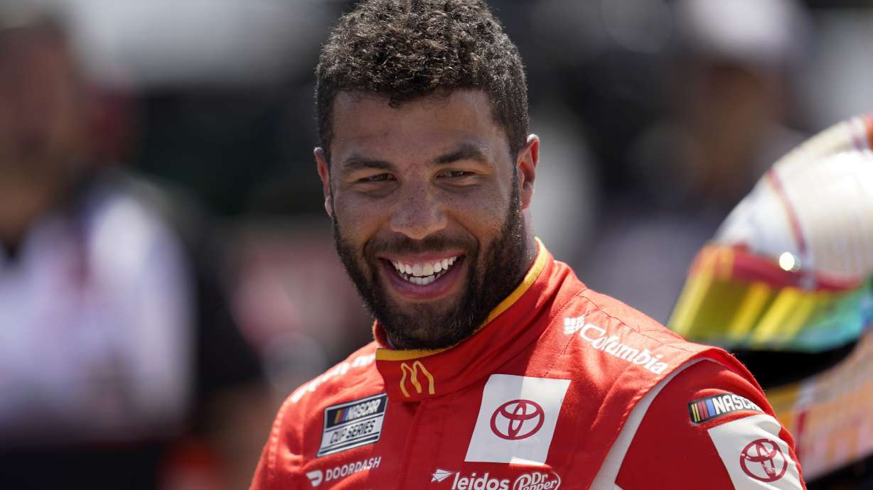 Bubba Wallace smiles during NASCAR Cup Series auto race qualifying at the Michigan International Speedway in Brooklyn, Mich., Saturday, Aug. 6, 2022. Wallace won the pole position.