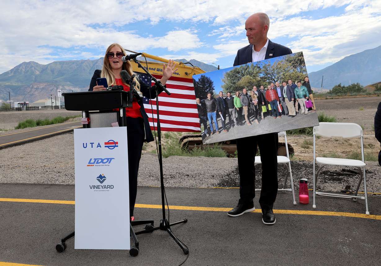 Vineyard Mayor Julie Fullmer presents a photo to Gov. Spencer Cox as she speaks during the opening of a new FrontRunner station in Vineyard on Friday.