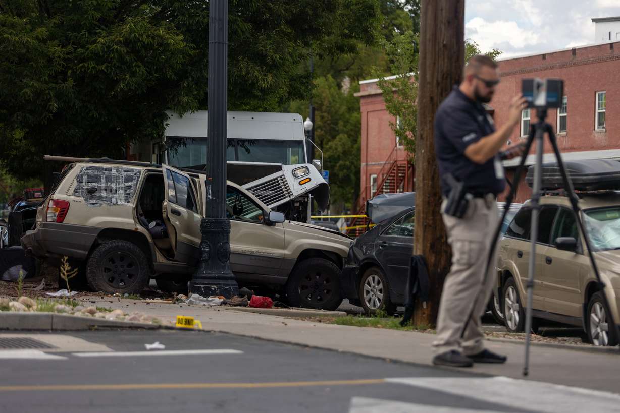 A police officer investigates a car crash that involved five vehicles at 450 S. 400 West in Salt Lake City on Friday, Aug. 12, 2022.