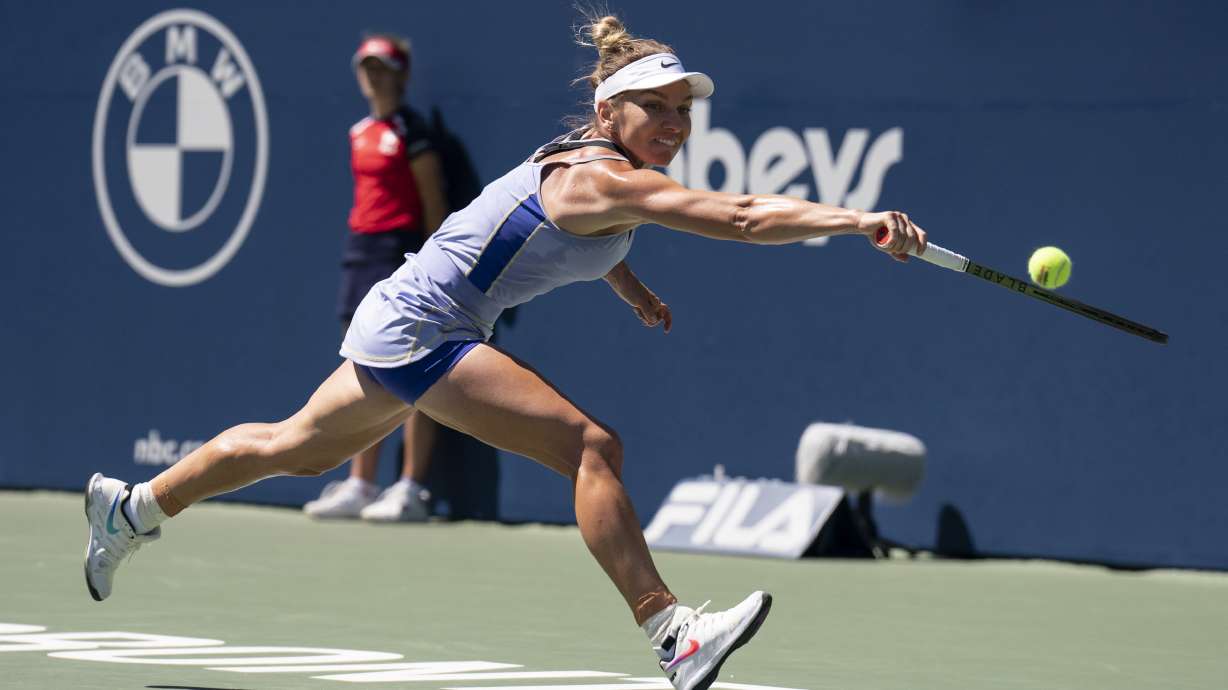 Romania's Simona Halep stretches to reach a shot from United States' Coco Gauff during Women's National Bank Open tennis match in Toronto, Friday, Aug. 12, 2022.