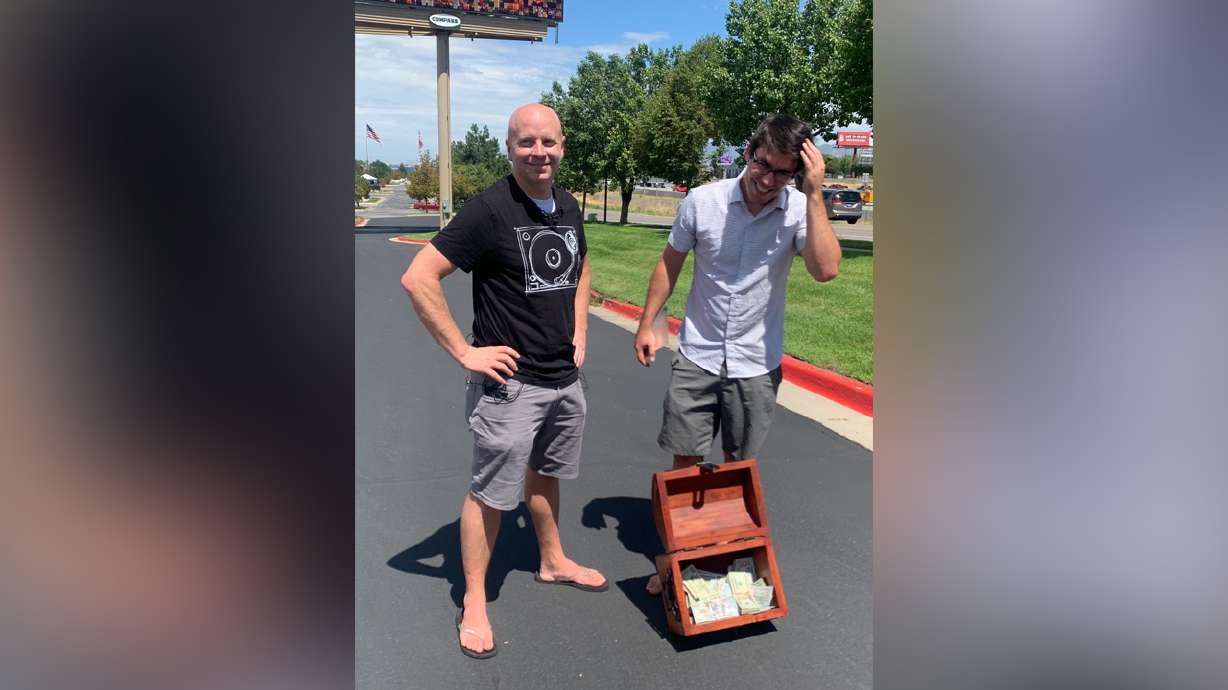 John Maxim, left, and David Cline show off the $20,000 up for grabs in their latest treasure hunt. The friends have released the first clue that will lead treasure hunters through a series of challenges and puzzles as they search for the prize.