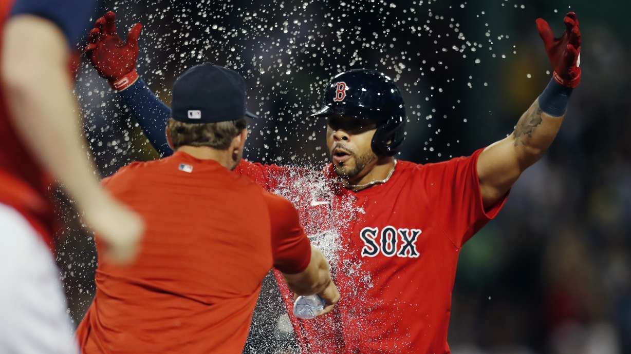 Boston Red Sox's Tommy Pham, right, celebrates after hitting a walkoff RBI-single during the 10th inning of a baseball game against the New York Yankees, Friday, Aug. 12, 2022, in Boston.