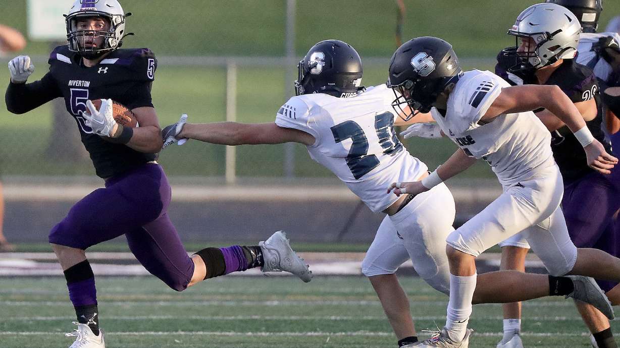 Riverton’s Easton Hicks runs past the reach of Syracuse High’s Eason Craythorne during a varsity football game at Riverton High School in Riverton on Friday, Aug. 12, 2022. Riverton won 27-25.