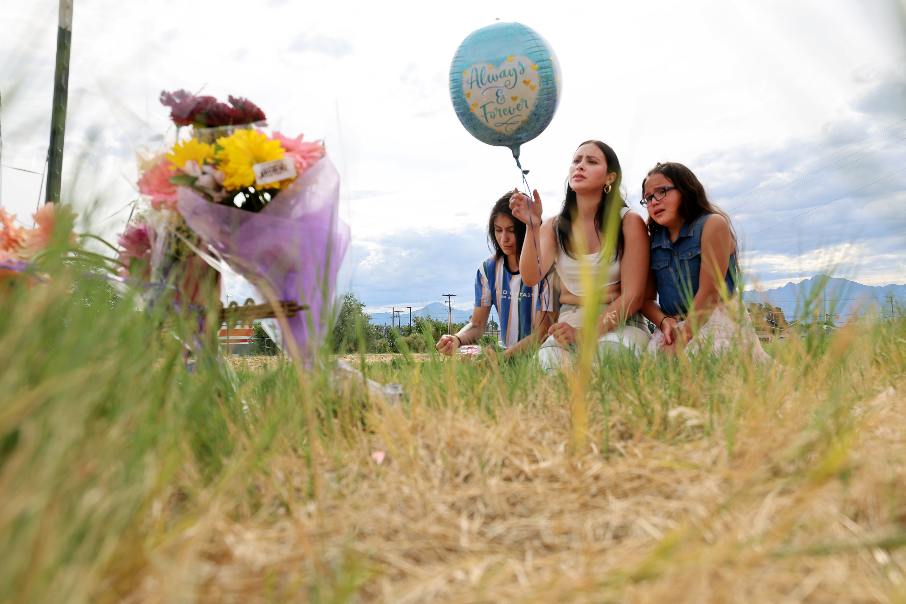 Some members of Rosie Tapia's family sit on the bank of the Jordan River on Saturday near the area her body was found. The reward for information in her case has now been set at $100,000.