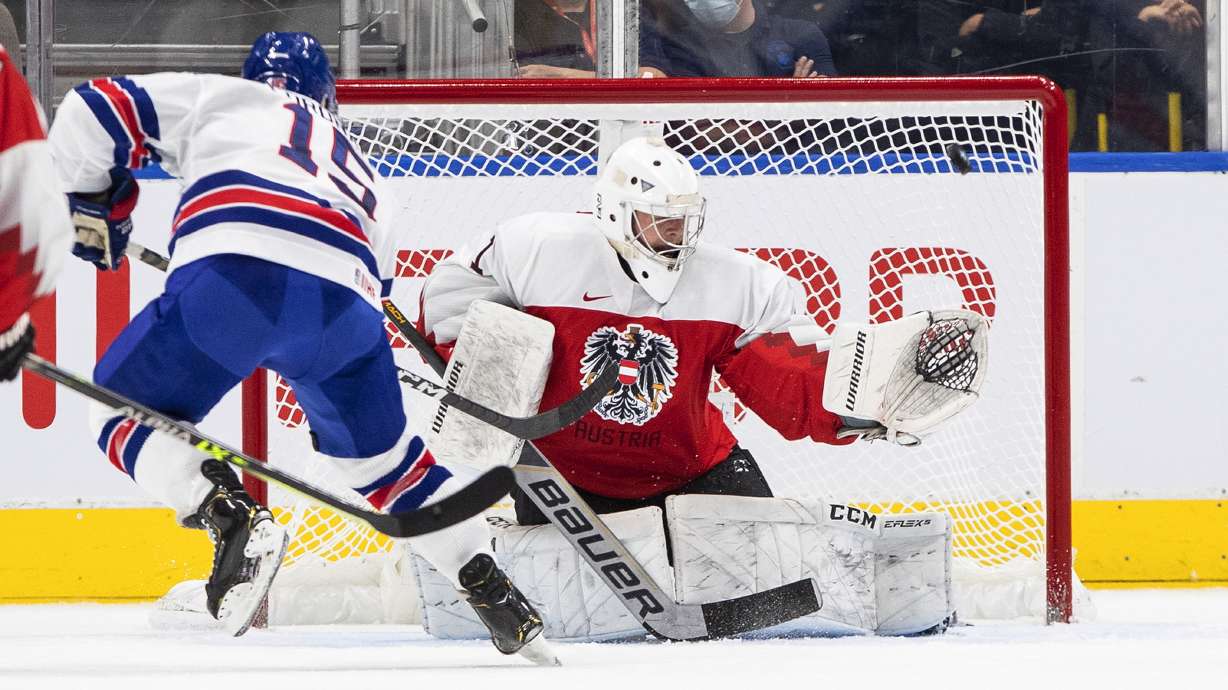 United States' Matthew Coronato (15) hits the post as Austria's goalie Leon Sommer (1) tries to make a save during the first period of an IIHF World Junior Hockey Championship game in Edmonton, Alberta, Saturday, Aug. 13, 2022.