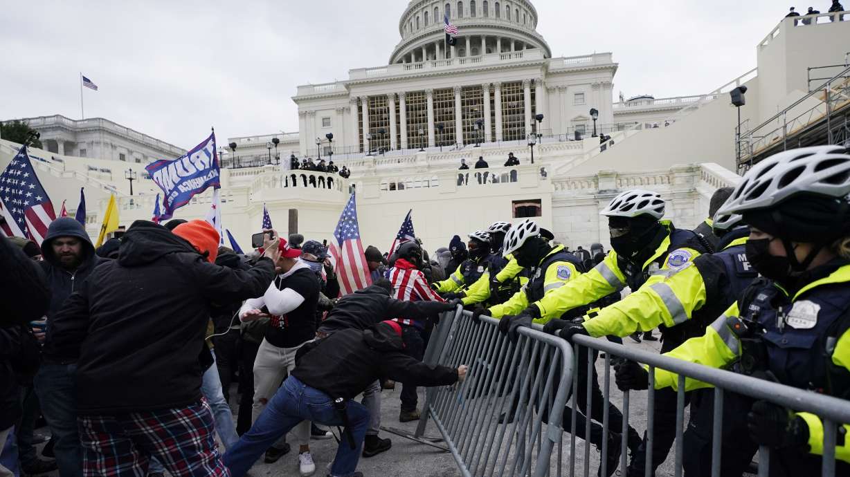 Insurrectionists loyal to President Donald Trump try to break through a police barrier Jan. 6, 2021, at the Capitol in Washington. Facing prison time and dire personal consequences for storming the U.S. Capitol, some Jan. 6 defendants are trying to profit from their participation in the deadly riot.