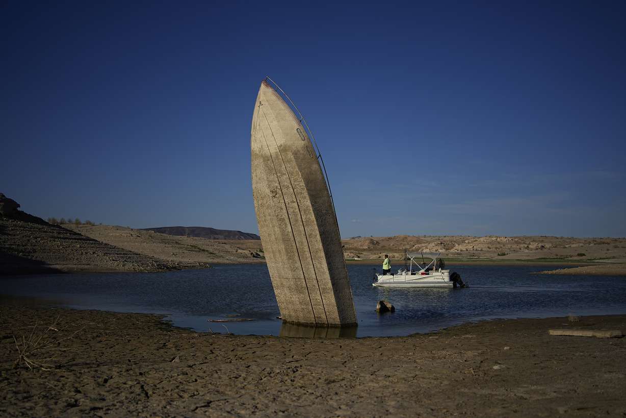 A formerly sunken boat sits upright into the air with its stern stuck in the mud along the shoreline of Lake Mead at the Lake Mead National Recreation Area, June 10, near Boulder City, Nev. Lake Mead water has dropped to levels it hasn't been since the lake initially filled over 80 years earlier.