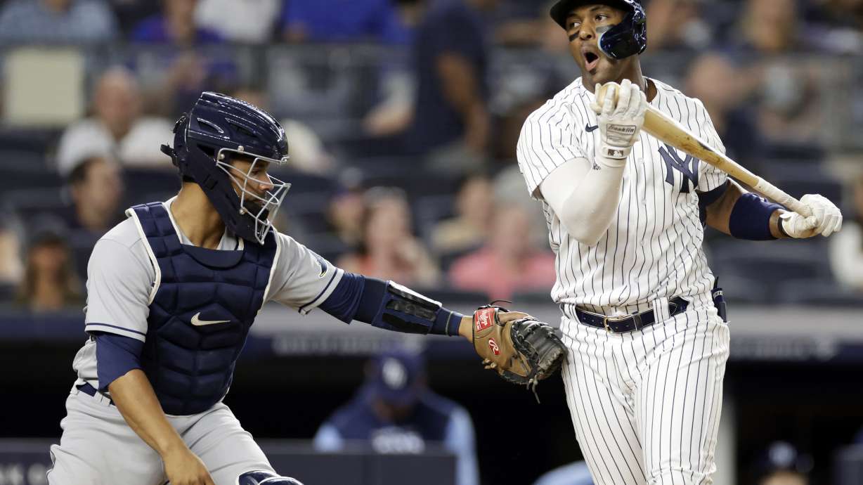 New York Yankees designated hitter Miguel Andujar reacts after striking out then being tagged by Tampa Bay Rays catcher Francisco Mejia during the sixth inning of a baseball game Monday, Aug. 15, 2022, in New York.