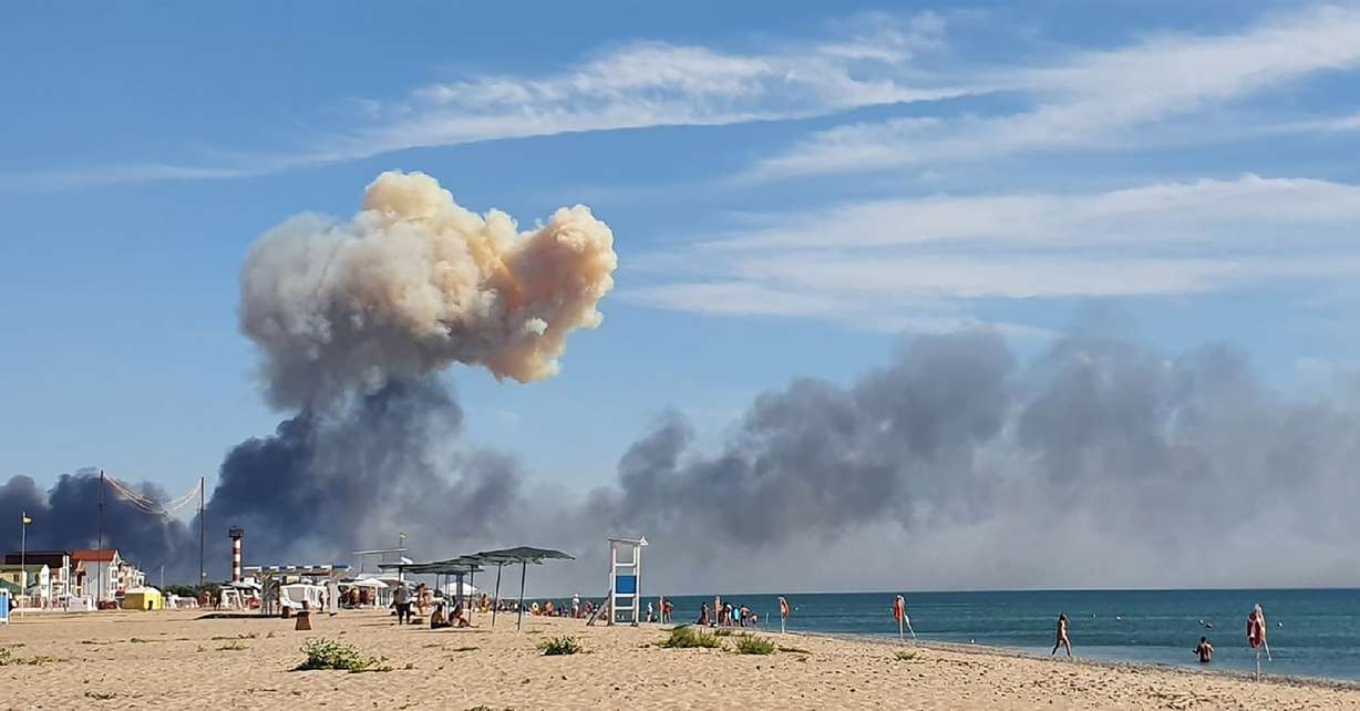 Rising smoke can be seen from the beach at Saky after explosions were heard from the direction of a Russian military airbase near Novofedorivka, Crimea, Aug. 9. More massive explosions and fires hit a military depot in Russia-annexed Crimea on Tuesday.