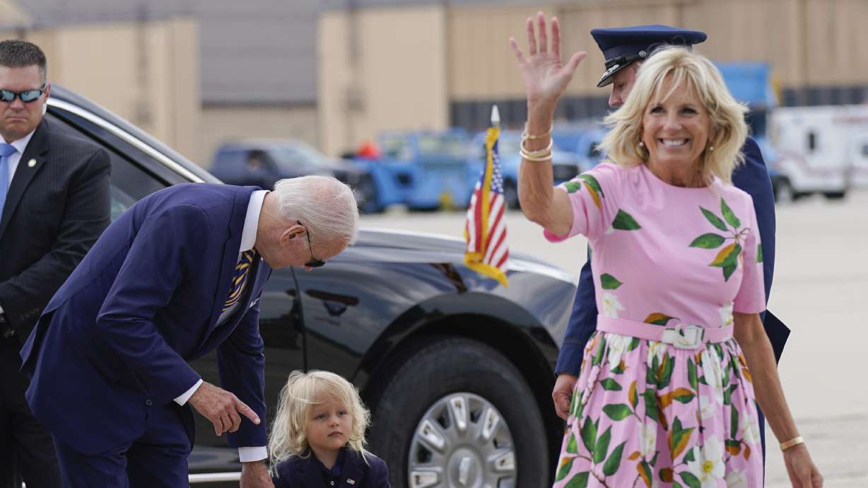 President Joe Biden looks at his grandson Beau Biden as first lady Jill Biden waves and walks to board Air Force One at Andrews Air Force Base, Md., Wednesday. First lady Jill Biden tested positive for COVID-19 and is experiencing "mild symptoms" the White House announced Tuesday.
