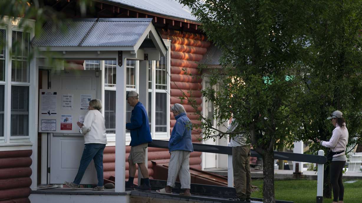 Voters wait in line outside a polling place during the Republican primary election in Wilson, Wyo., Tuesday.