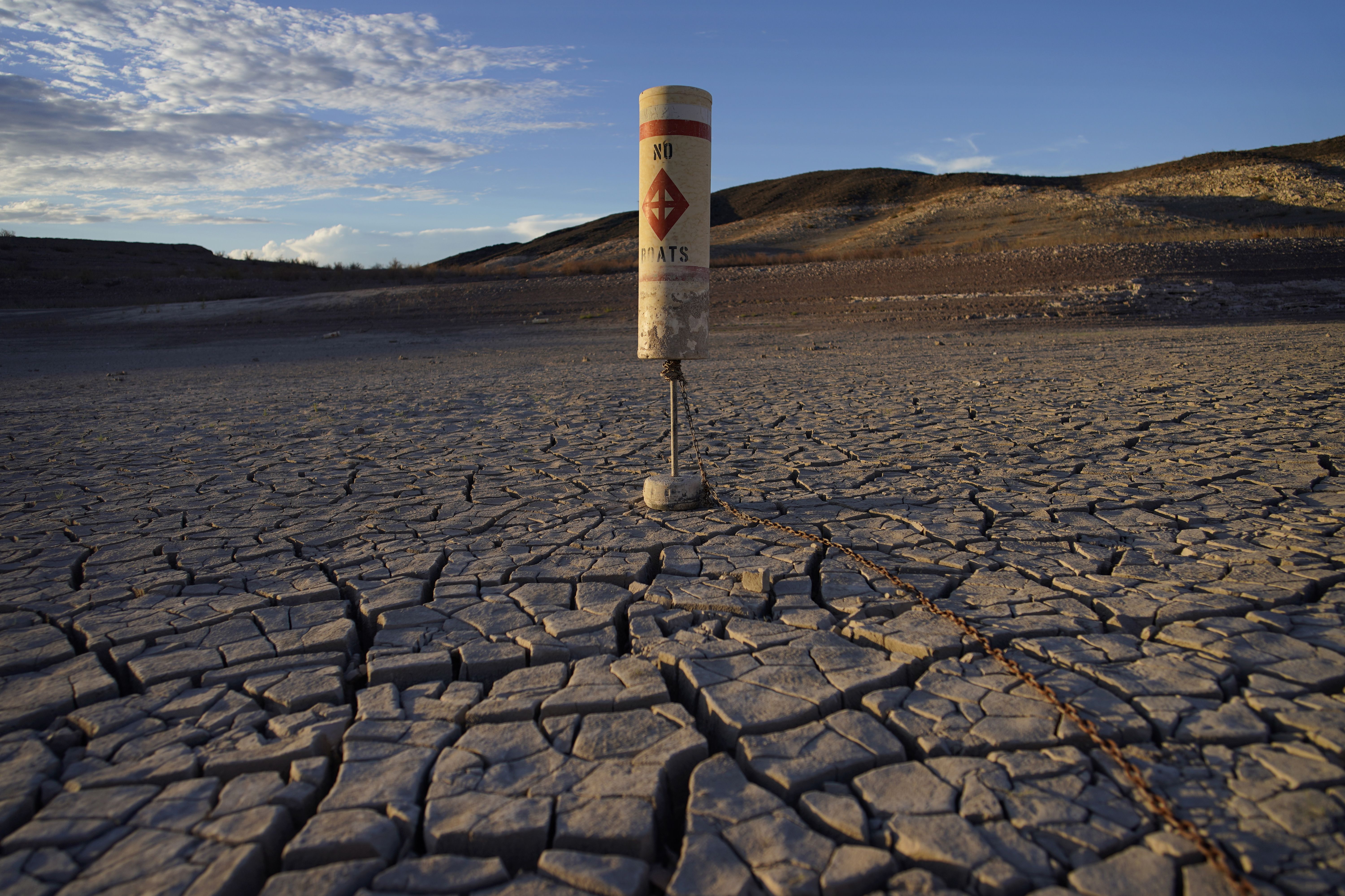 A buoy sits high and dry on cracked earth previously under the waters of Lake Mead at the Lake Mead National Recreation Area near Boulder City, Nev., on June 28. Federal officials on Tuesday, are expected to announce water cuts that would further reduce how much Colorado River water some users in the seven U.S. states reliant on the river and Mexico receive. 