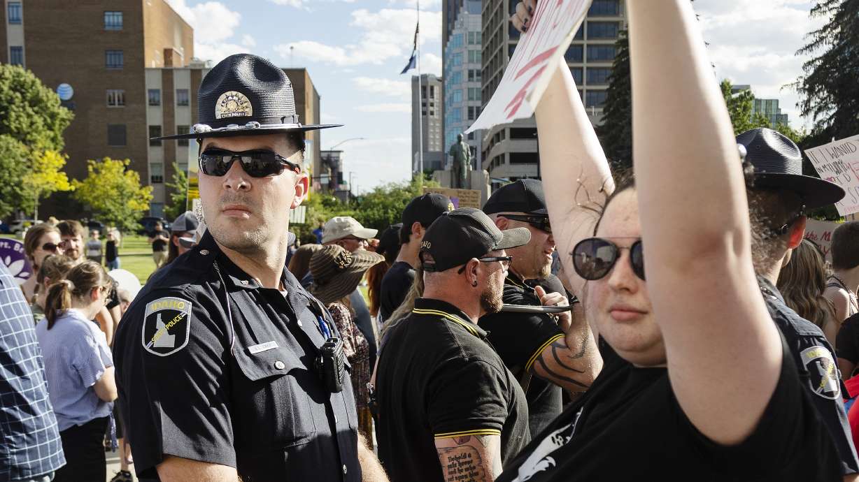 Idaho State Police form a line between those attending an anti-abortion celebration and protesters who came to support abortion rights at the Idaho Statehouse in Boise, on June 28. A legal battle over abortion rights pitting Idaho against the U.S. government has dozens of states and major medical associations seeking to weigh in.