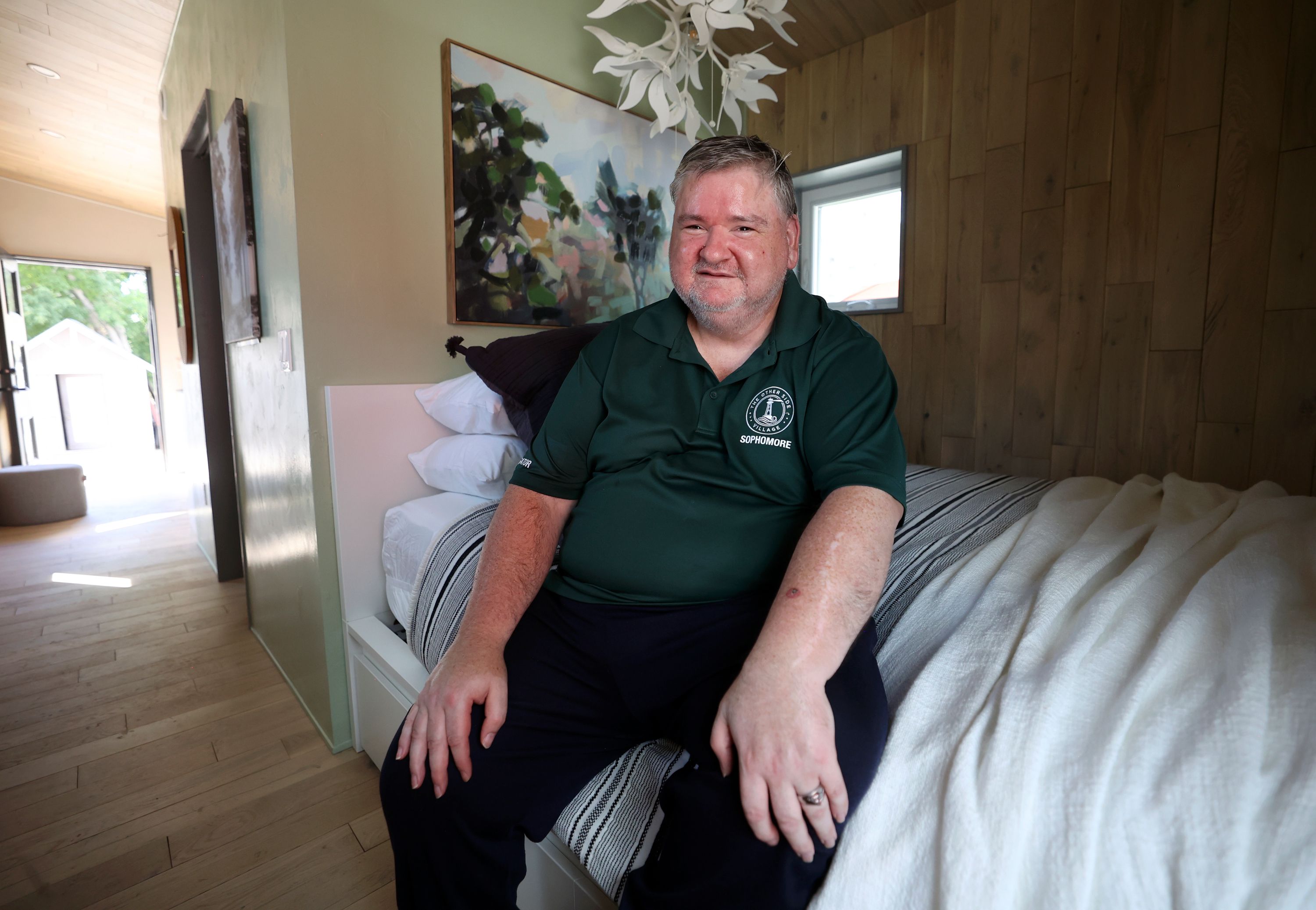 Jack Stiles, a sophomore neighbor at The Other Side Village, poses for a portrait in a 280-square-foot cottage that will be part of The Other Side Village, providing affordable, permanent housing for people coming out of chronic homelessness, like Stiles, in Salt Lake City on Wednesday. The home was designed and constructed as part of the University of Utah School of Architecture’s Design + Build Salt Lake program.