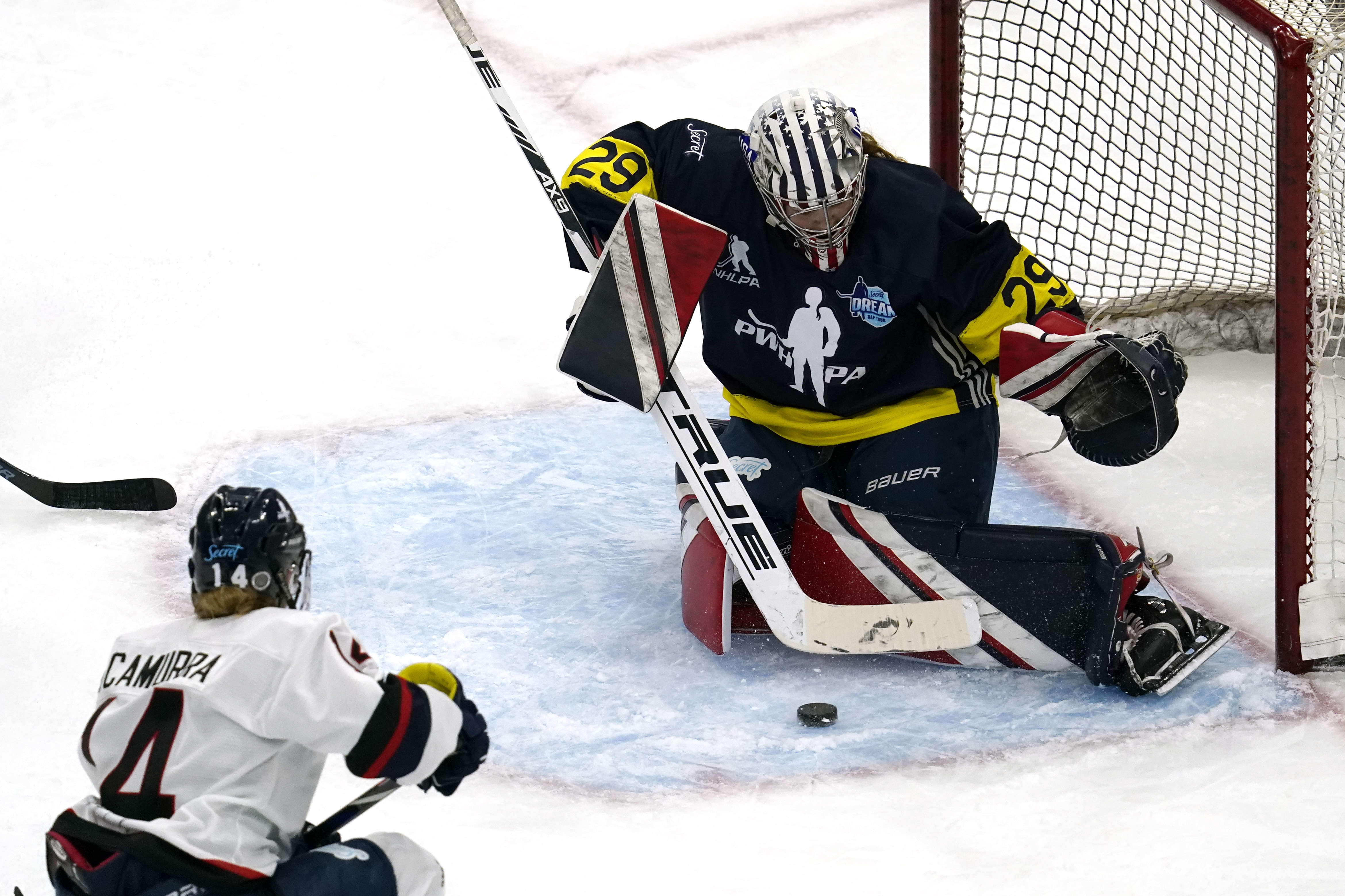 FILE- Team Adidas Minnesota goalie Nicole Hensley, right, makes a save on a shot by Women's Sports Foundation New Hampshire's Hayley Scamurra during the third period of the Dream Gap Tour hockey game at the United Center in Chicago, on March 6, 2021. The Professional Women’s Hockey Players’ Association is resuming its Dream Gap barnstorming tour for a fourth consecutive year, while still developing plans to launch a professional league.  