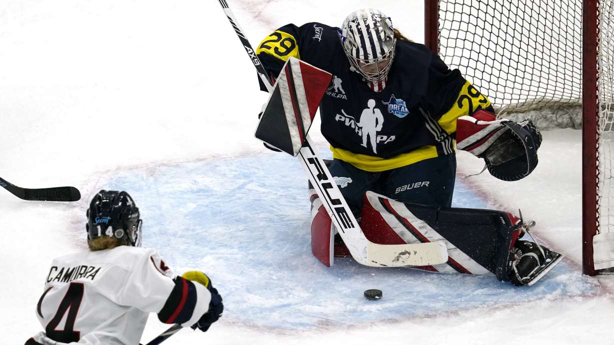 FILE- Team Adidas Minnesota goalie Nicole Hensley, right, makes a save on a shot by Women's Sports Foundation New Hampshire's Hayley Scamurra during the third period of the Dream Gap Tour hockey game at the United Center in Chicago, on March 6, 2021. The Professional Women’s Hockey Players’ Association is resuming its Dream Gap barnstorming tour for a fourth consecutive year, while still developing plans to launch a professional league.