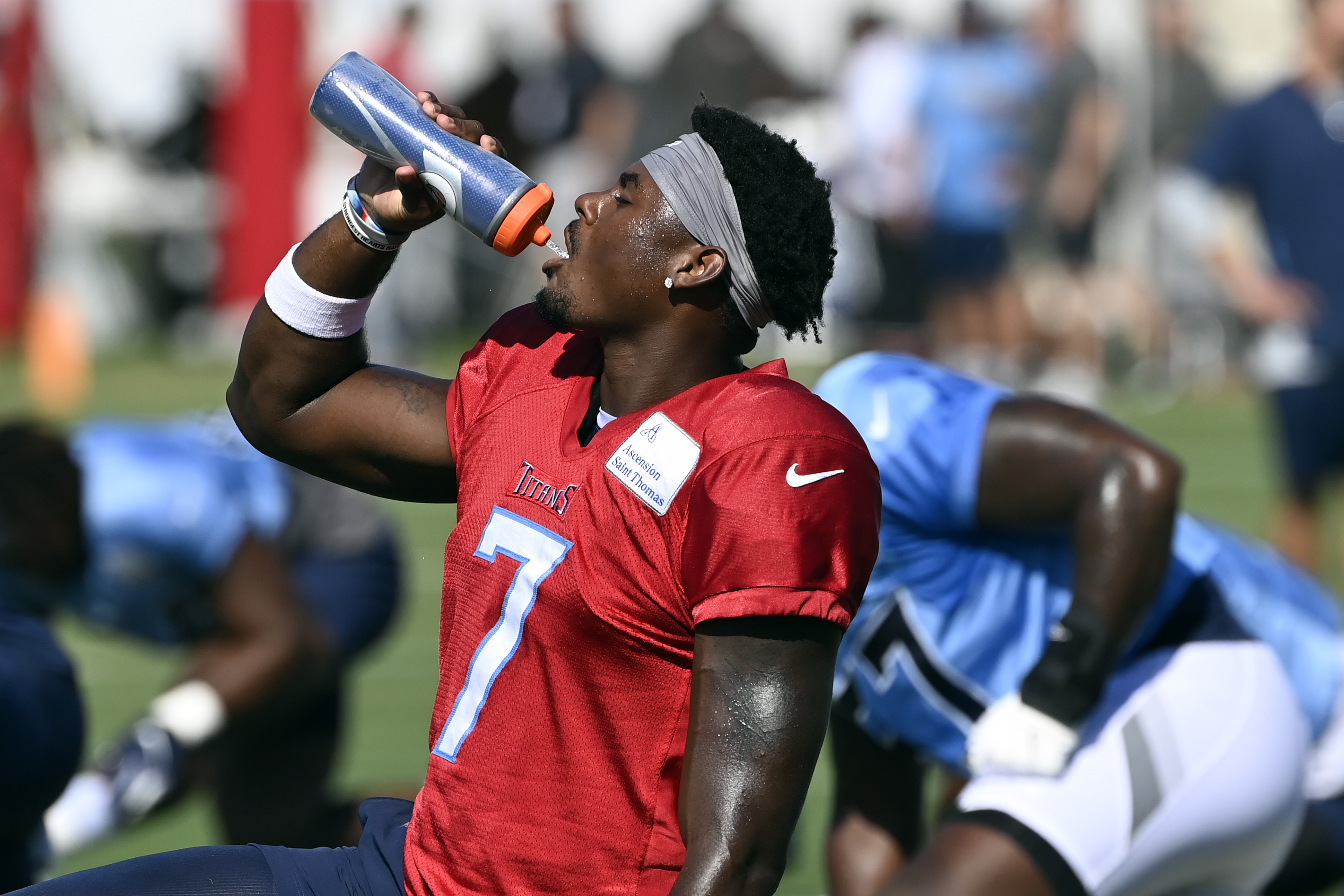 Tennessee Titans quarterback Malik Willis (7) gets a drink during a combined NFL football training camp with the Tampa Bay Buccaneers, Thursday, Aug. 18, 2022, in Nashville, Tenn. 