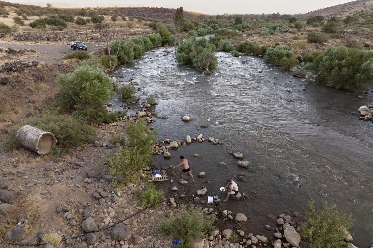 People bathe in the Jordan River near Kibbutz Karkom in northern Israel on July 30. The river's decline is intertwined with the decades-old Arab-Israeli conflict and rivalries over precious water supplies in an area where so much is contested.
