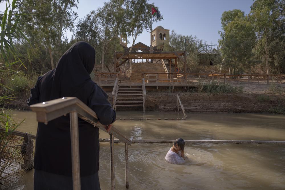 Olga Bokkas, a visitor from Connecticut, immerses herself in the waters of the Jordan River at the Qasr al-Yahud baptismal site, near the West Bank town of Jericho on July 31. The river’s dwindling waters are sluggish and a dull brownish green in this area.