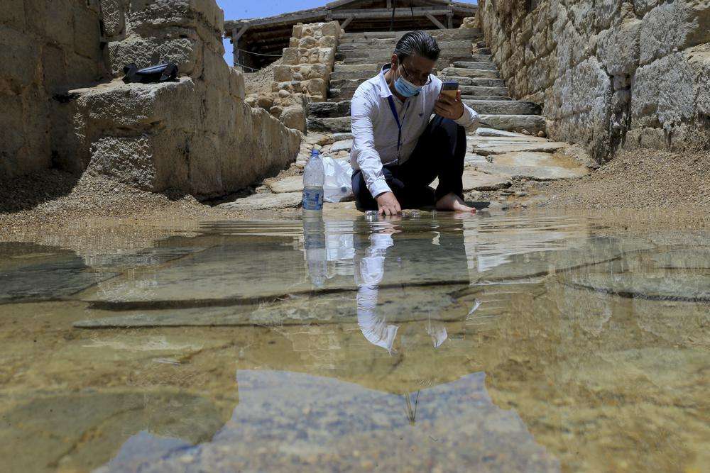 Syrian Christian Zuhair Al-Sahawi immerses his hand in water at the Bethany Beyond the Jordan baptismal site on the east bank of the Jordan River in Jordan on June 8.