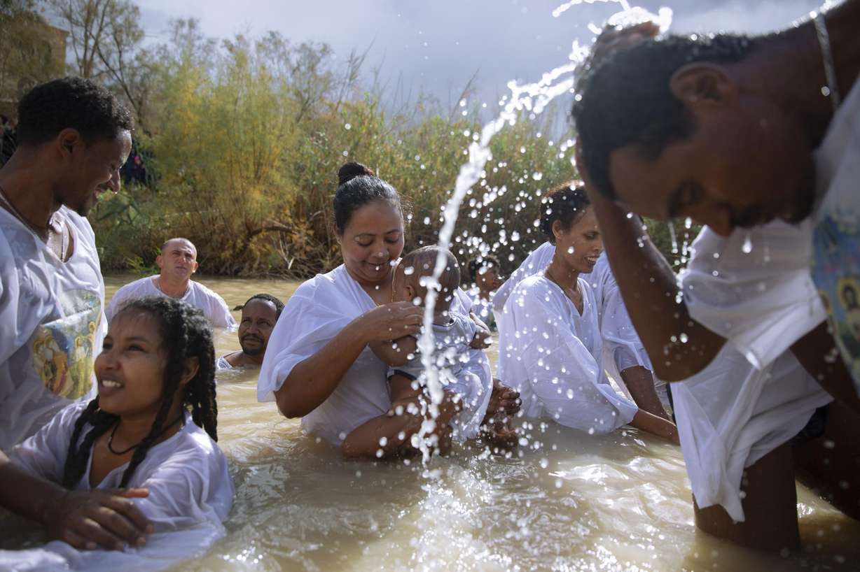 Members of the Eritrean and Ethiopian Christian Orthodox community from Tel Aviv participate in a baptismal ceremony in the waters of the Jordan River as part of the Orthodox Feast of the Epiphany at the Qasr al-Yahud baptismal site, near the West Bank town of Jericho on Jan. 19, 2018.