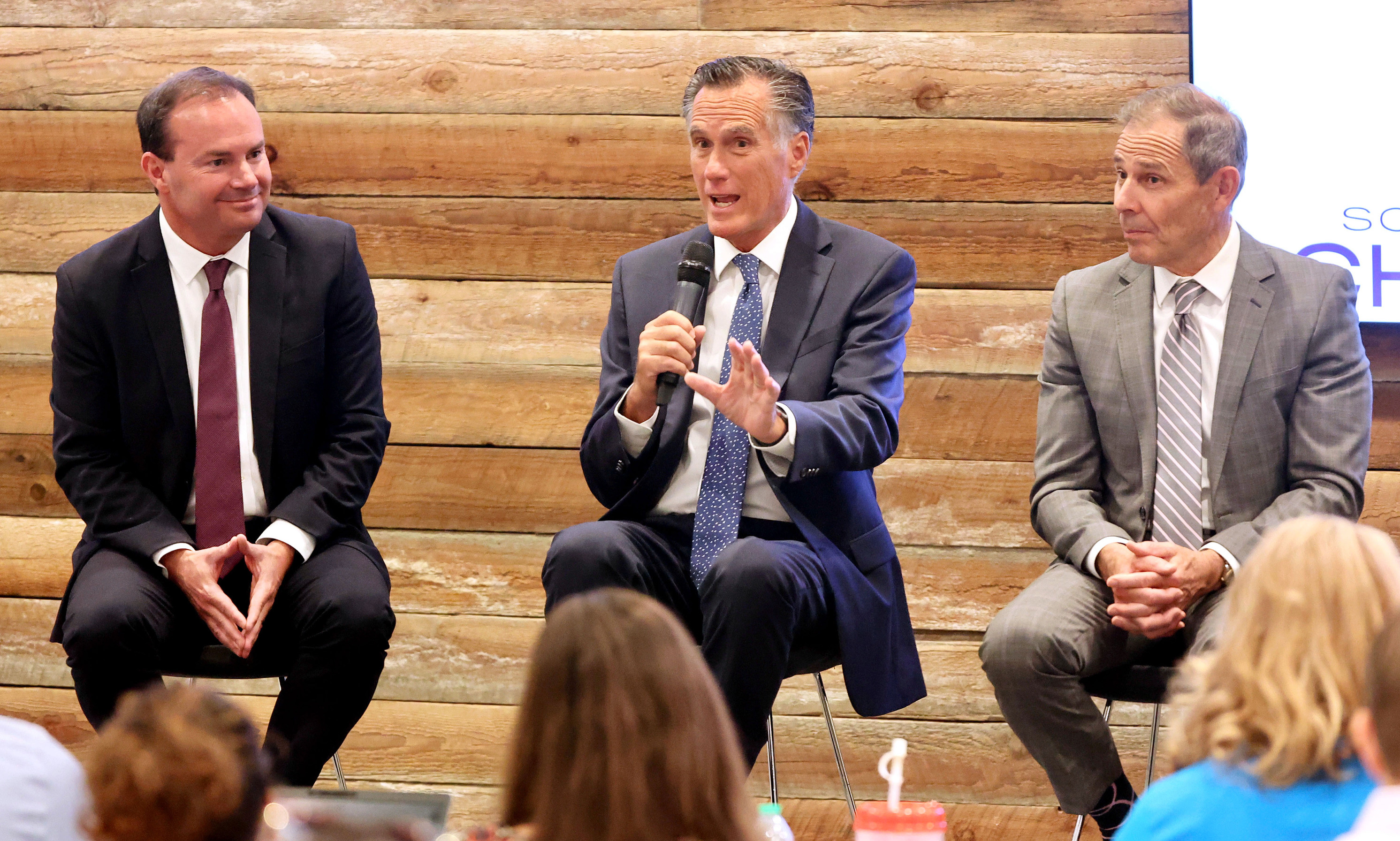 Sen. Mike Lee, R-Utah, left, and Rep. John Curtis, right, listen as Sen. Mike Romney, R-Utah, center, addresses the South Valley Chamber of Commerce gathering at the Salt Mine Productive Workspace in Sandy on Thursday.