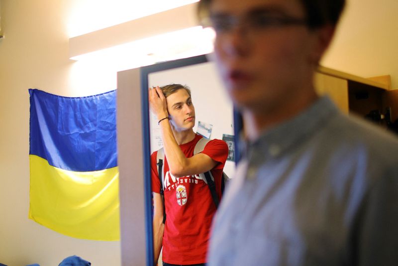 Hlib Burtsev is reflected in a mirror as he and and Oleksii Shebanov, both from Ukraine, stand in his dorm room ahead of their first year at Brown University in Providence, Rhode Island, Tuesday. More than 120 U.S. universities have efforts to help Ukrainian students, according to a survey of 559 schools by the Institute of International Education, though the actual number is likely far higher.