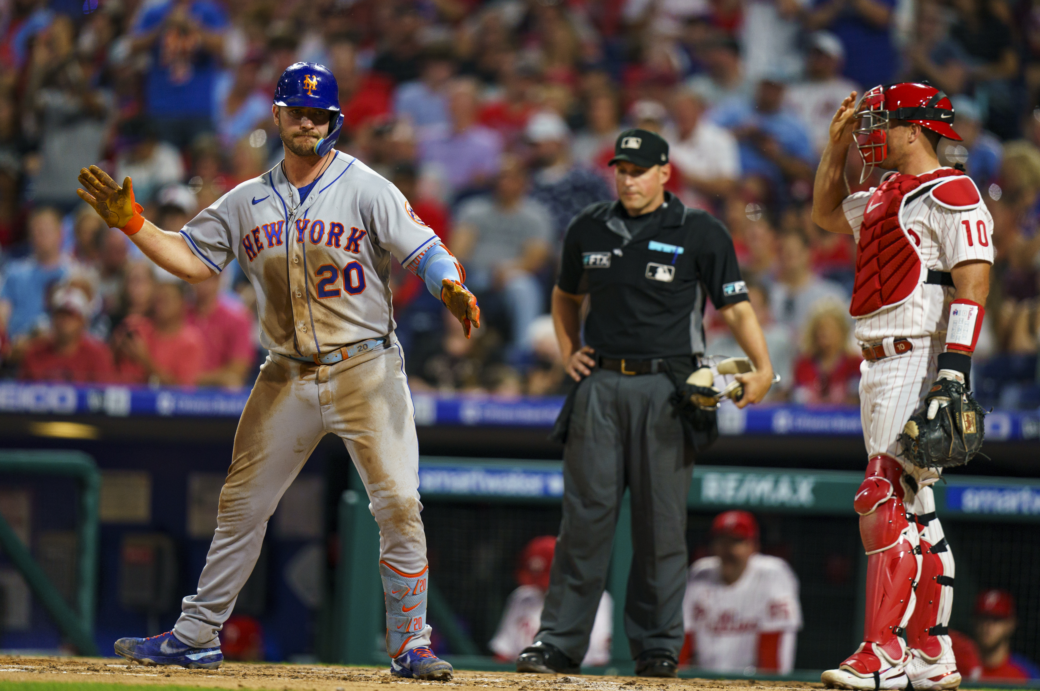 New York Mets' Pete Alonso, left, reacts to his home run as Philadelphia Phillies catcher J.T. Realmuto, right, looks on during the third inning of a baseball game, Friday, Aug. 19, 2022, in Philadelphia. 