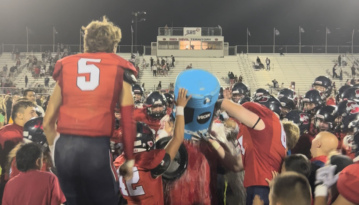 Springville players pour water on head coach David Valeti after 45-17 win over Skyline on Valeti's birthday.