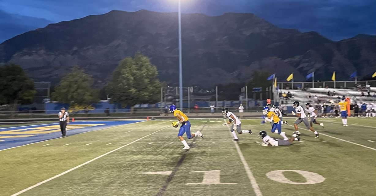 Orem wide receiver Roger Saleapaga runs away from Desert Pines defenders to score the winning touchdown in a game on August 19, 2022.