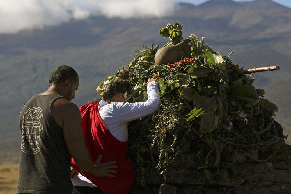 Native Hawaiian activists pray at the base of Hawaii's Mauna Kea, in the background on July 14, 2019. For over 50 years, telescopes have dominated the summit of Mauna Kea, a place sacred to Native Hawaiians and one of the best places in the world to study the night sky.