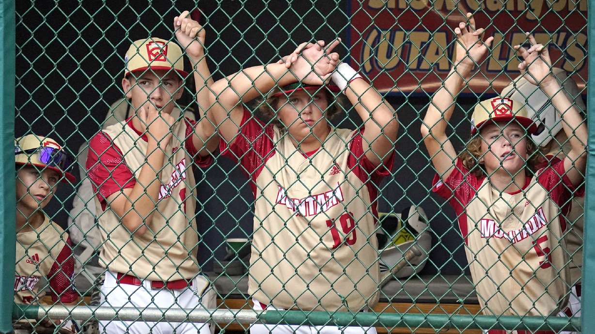 Santa Clara, Utah, players watch from the dugout during the fifth inning of a baseball game against Davenport, Iowa, at the Little League World Series in South Williamsport, Pa., Sunday, Aug. 21, 2022. From left to right, Chaz Hickman, Brogan Coop, Brex Whitney (19), and Cody Ruffell (5).