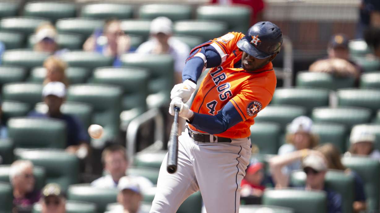 Houston Astros' Yordan Alvarez hits a single and scores Chas McCormick and Mauricio Dubon in the third inning of a baseball game against the Atlanta Braves Sunday, Aug. 21, 2022, in Atlanta.