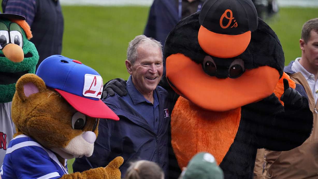 Former President George W. Bush, center, is surrounded by mascots during pre-game festivities before the MLB Little League Classic baseball game between the Baltimore Orioles and the Boston Red Sox in Williamsport, Pa., Sunday, Aug. 21, 2022.