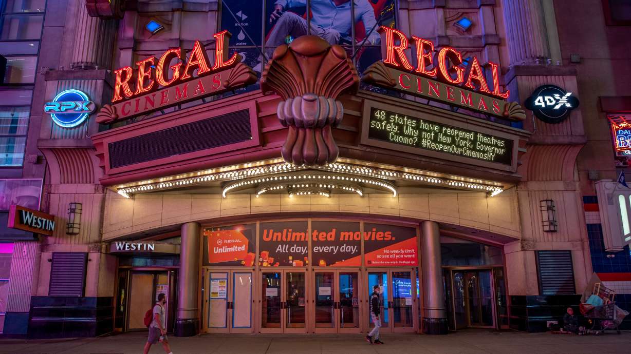Pedestrians pass in front of a Regal Cinemas movie theater in New York, Oct. 6, 2020. The movie theater chain may be filing for bankruptcy.