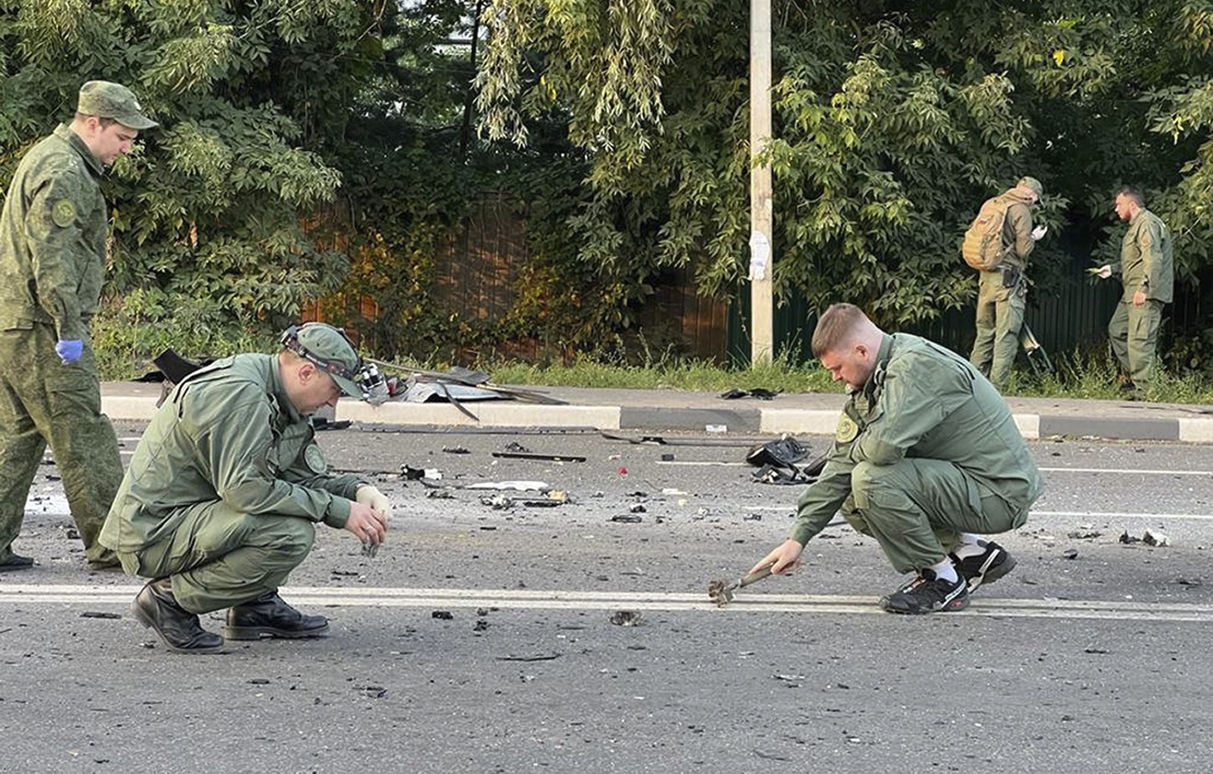 In this handout photo taken from video released by Investigative Committee of Russia on Sunday, investigators work on the site of explosion of a car driven by Daria Dugina outside Moscow.