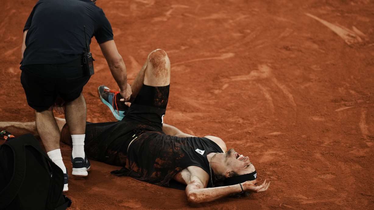 FILE - Germany's Alexander Zverev grimaces in pain after twisting his ankle during the semifinal match against Spain's Rafael Nadal at the French Open tennis tournament in Roland Garros stadium in Paris, France, Friday, June 3, 2022. Zverev, the 2020 U.S. Open runner-up and No. 2-ranked player, will miss the tournament this year while recovering from surgery on his right ankle. Zverev withdrew from the U.S. Open on Monday, Aug. 22, 2022.