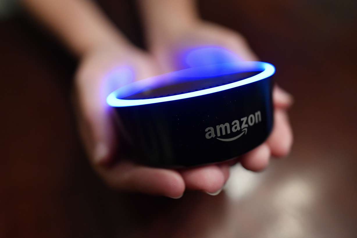 A child holds his Amazon Echo Dot in Kennesaw, Ga., Aug. 16, 2018. From what you buy online, to how you remember tasks, to when you monitor your doorstep, Amazon is seemingly everywhere.