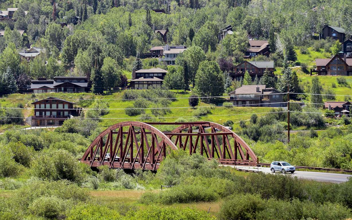 A motorist passes through a hillside community, Aug. 4, in Steamboat Springs, Colo.