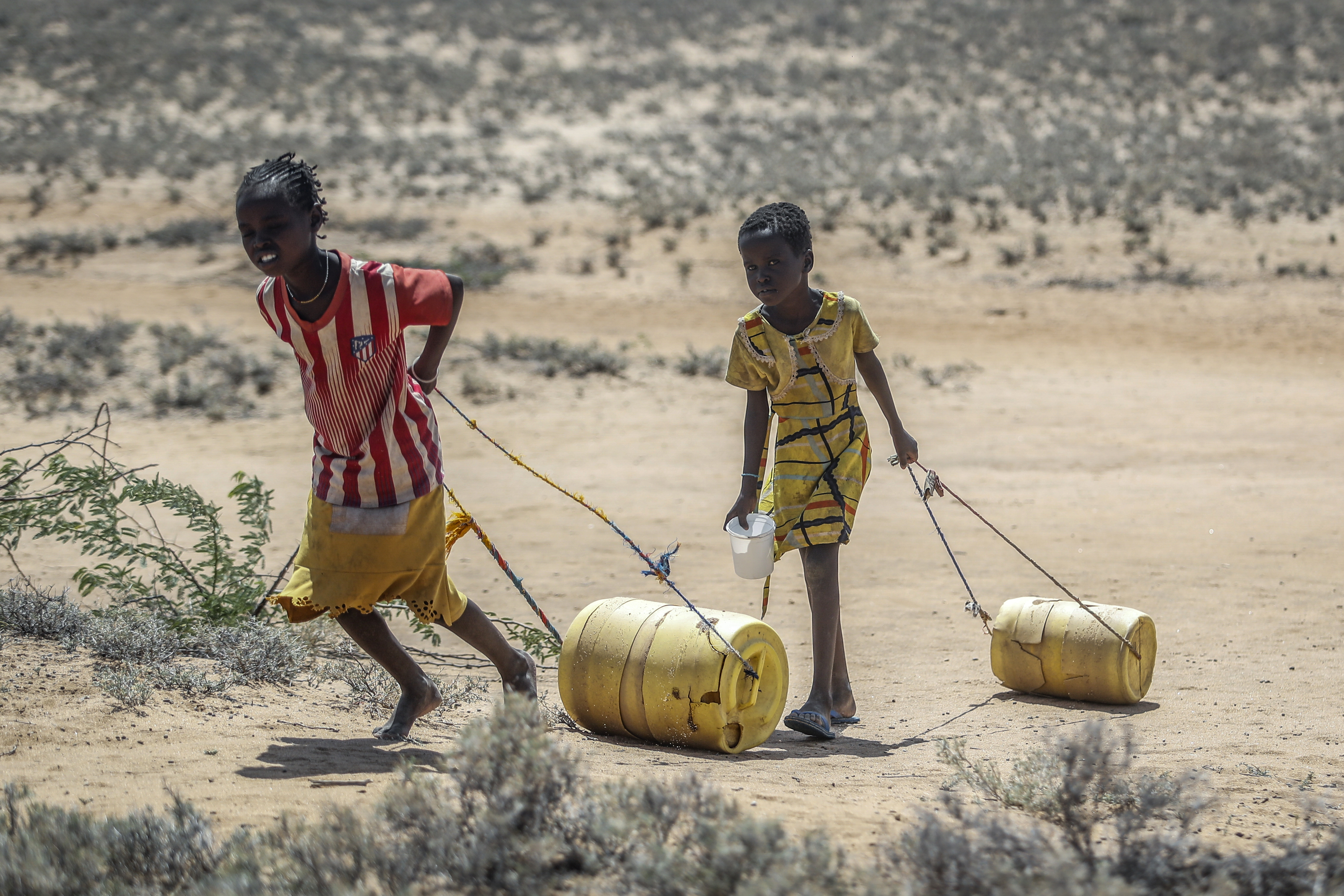 Young girls pull containers of water as they return to their huts from a well in the village of Lomoputh in northern Kenya on May 12.