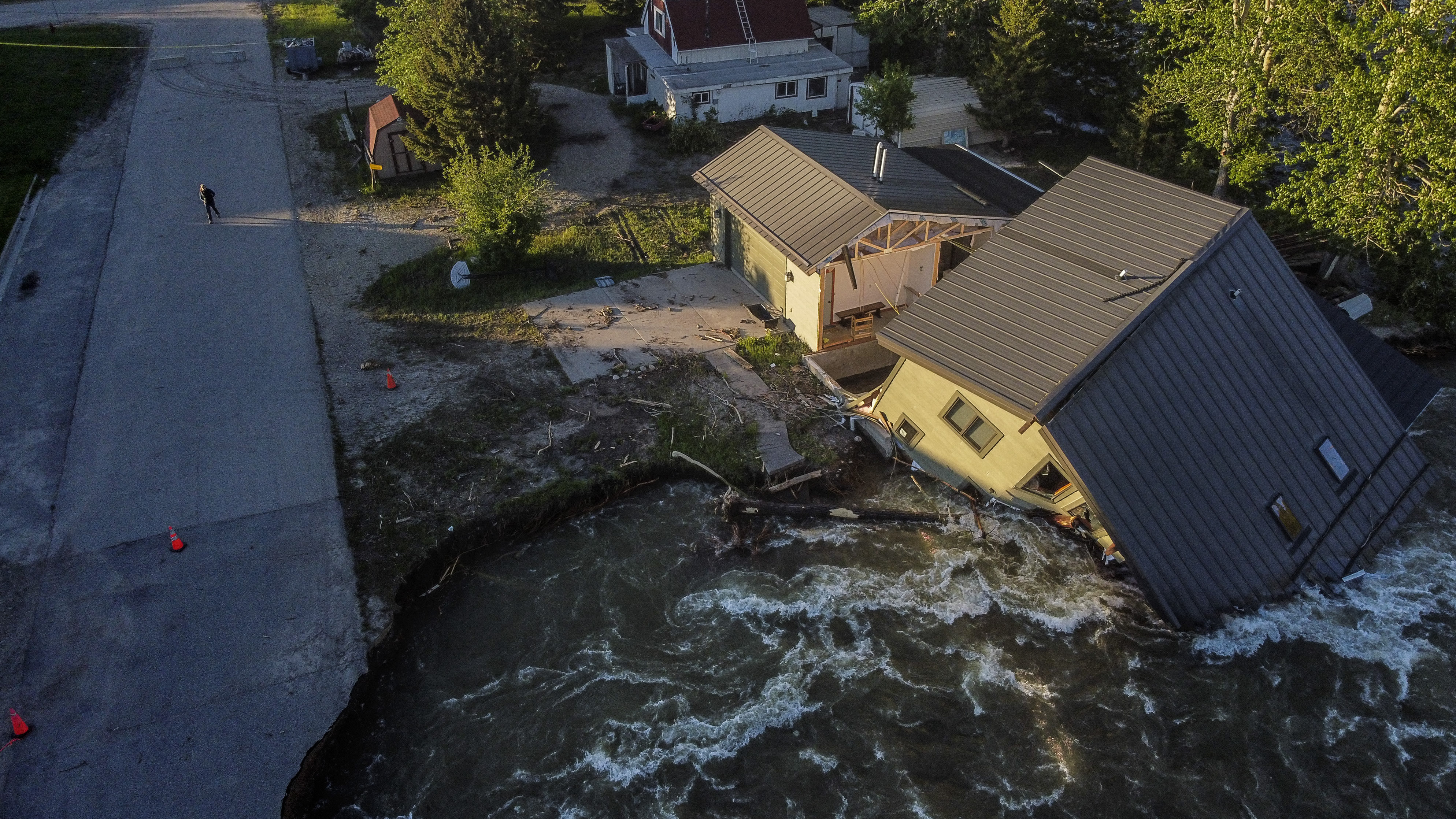 A house sits in Rock Creek after floodwaters washed away a road and a bridge in Red Lodge, Mont., June 15.