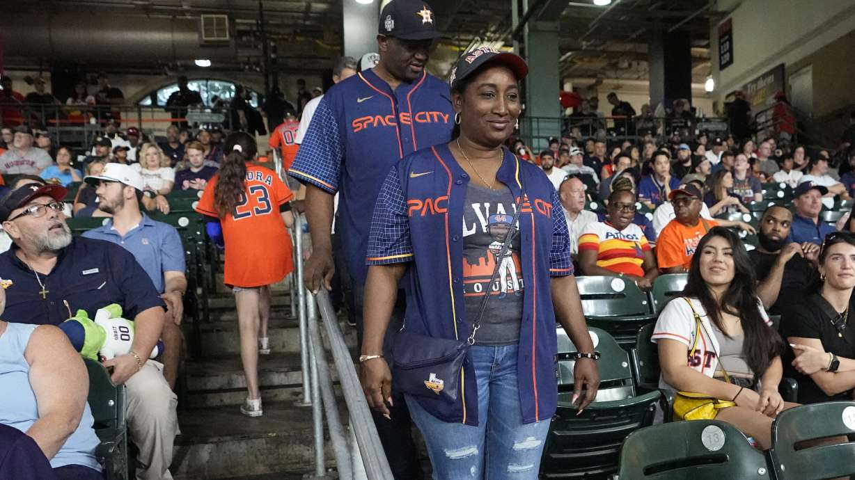 The parents of Houston Astros' Yordan Alvarez, Agustín Eduardo Álvarez Salazar, rear, and Mailyn Cadogan Reyes walk to their seats to watch the Minnesota Twins and Houston Astros play a baseball game Tuesday, Aug. 23, 2022, in Houston. Alvarez's parents got to see him play as a professional for the first time Tuesday night after arriving from Cuba Friday.