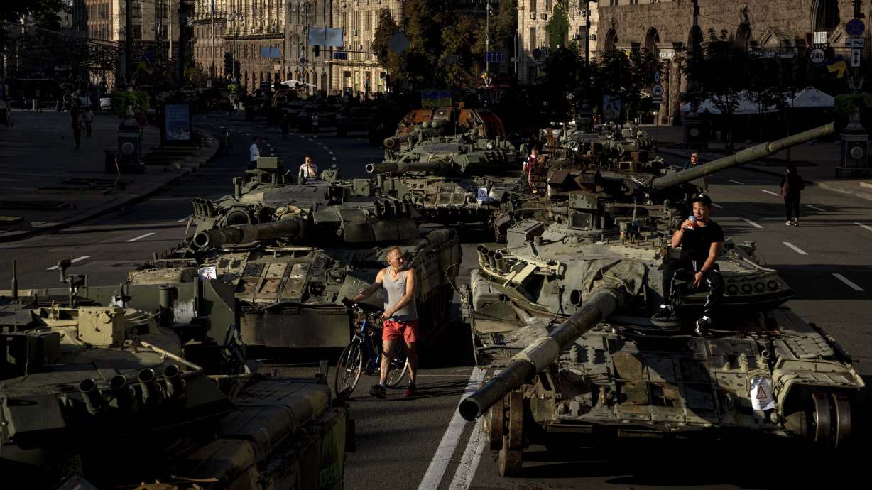 People walk around destroyed Russian military vehicles installed in downtown Kyiv, Ukraine, Wednesday. Kyiv authorities have banned mass gatherings in the capital through Thursday for fear of Russian missile attacks. Independence Day, like the six-month mark in the war, falls on Wednesday.