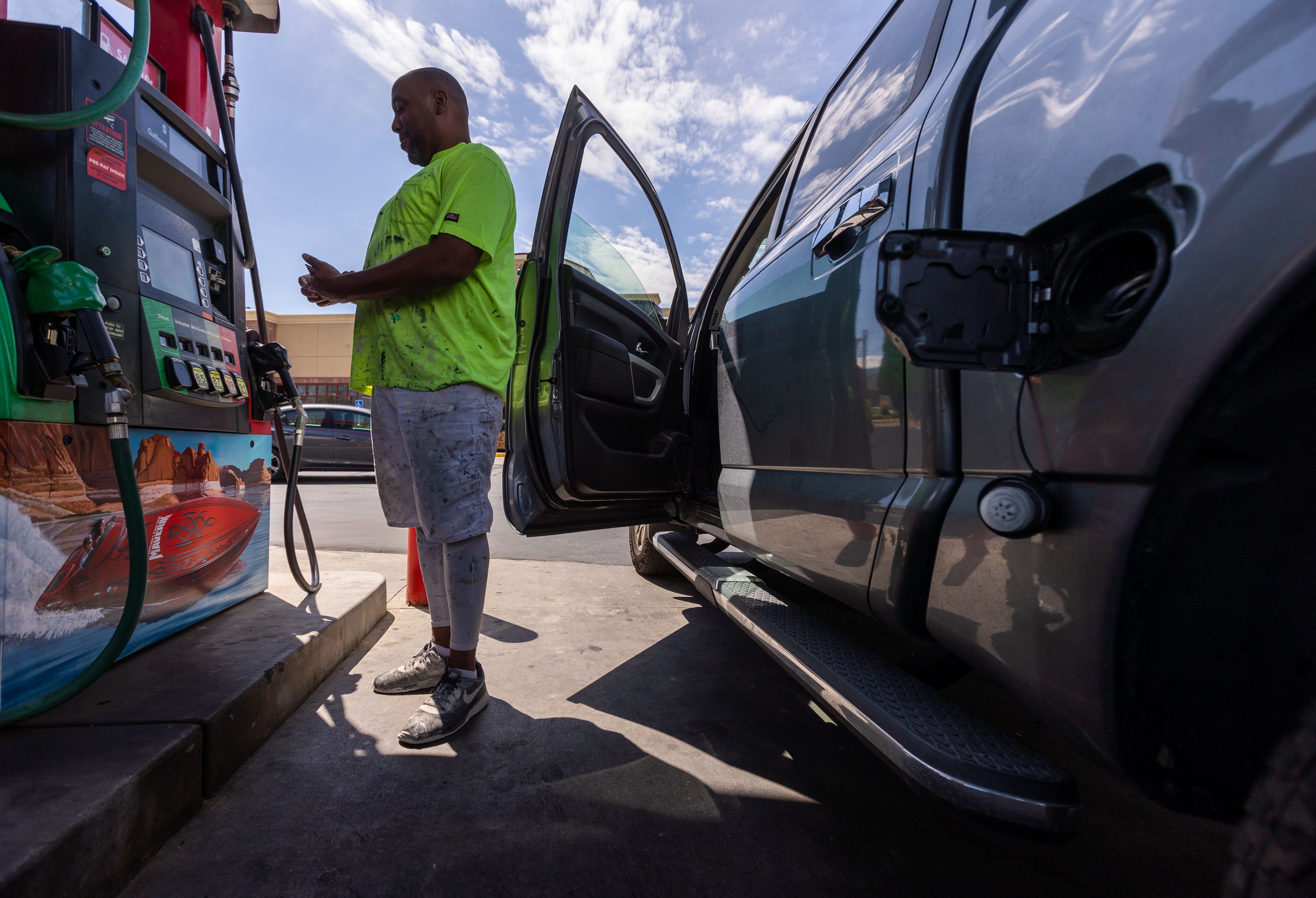 Jesse Griffin, owner of BLS Collective, a flooring and painting company, pays at a fuel pump before filling his work truck at a Maverik gas station in Midvale on Aug. 11. Gas prices remain higher than they were a year ago, but the average cost for a gallon of regular has dropped nationwide for 70 straight days.